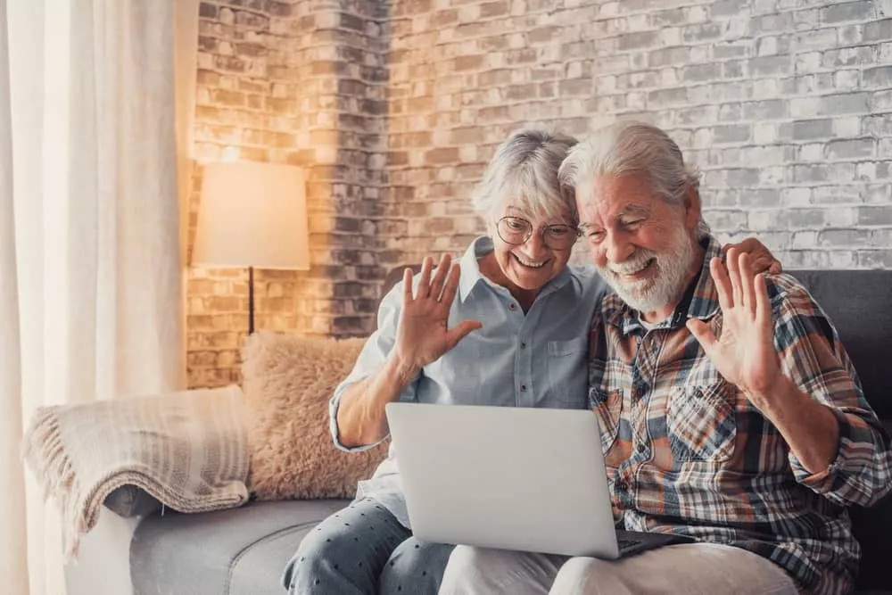 Couple de personnes âgées à la recherche d'une mutuelle senior sur un ordinateur