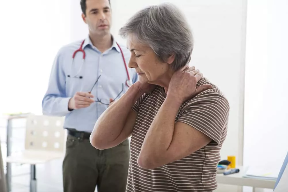 Une personne âgée consulte un medecin car elle a de l'arthrose cervicale