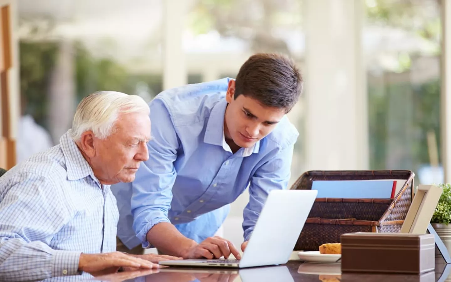 Homme âgé à la recherche d'une mutuelle senior 80 ans sur un ordinateur