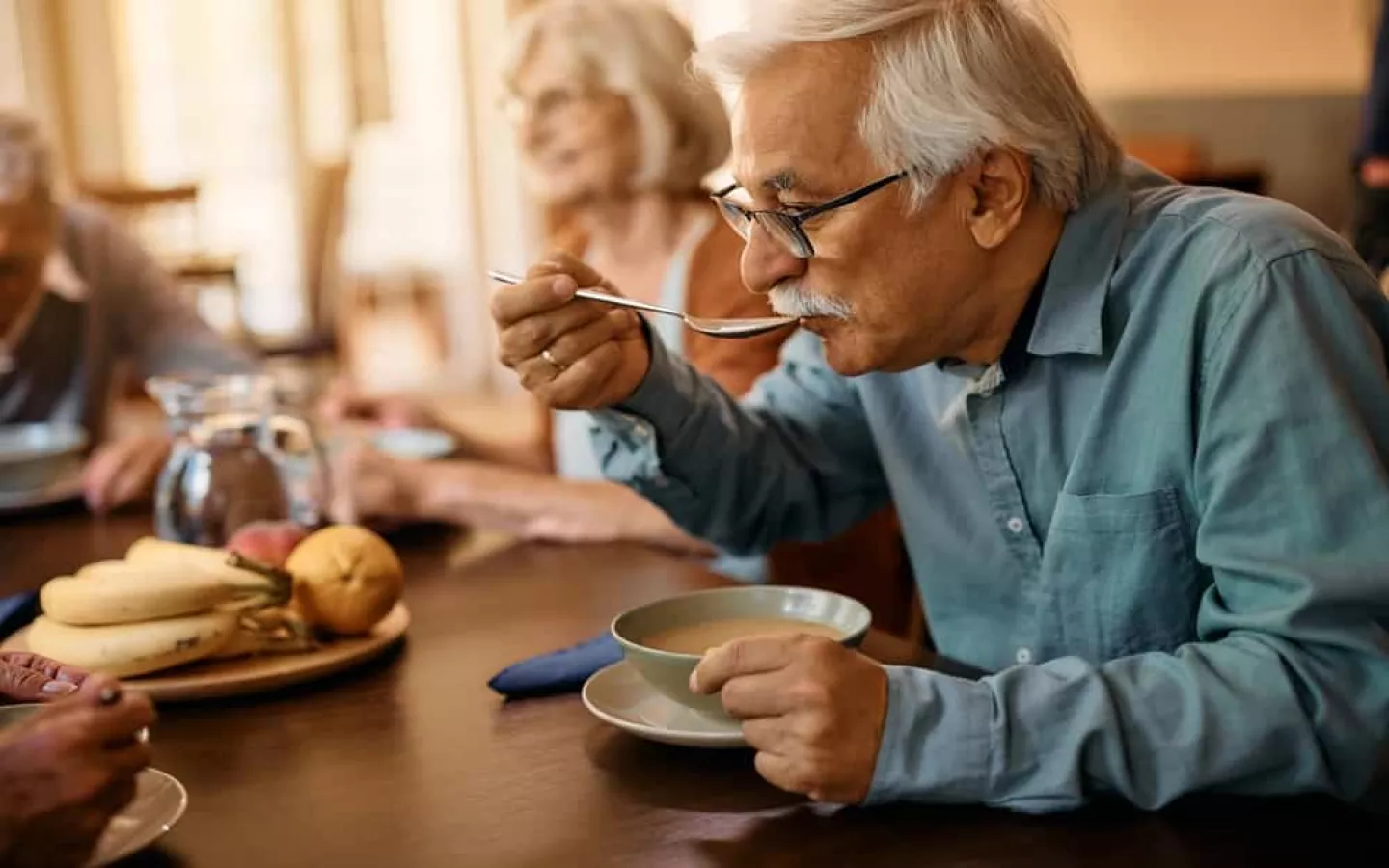 Une personne âgée qui mange de la soupe