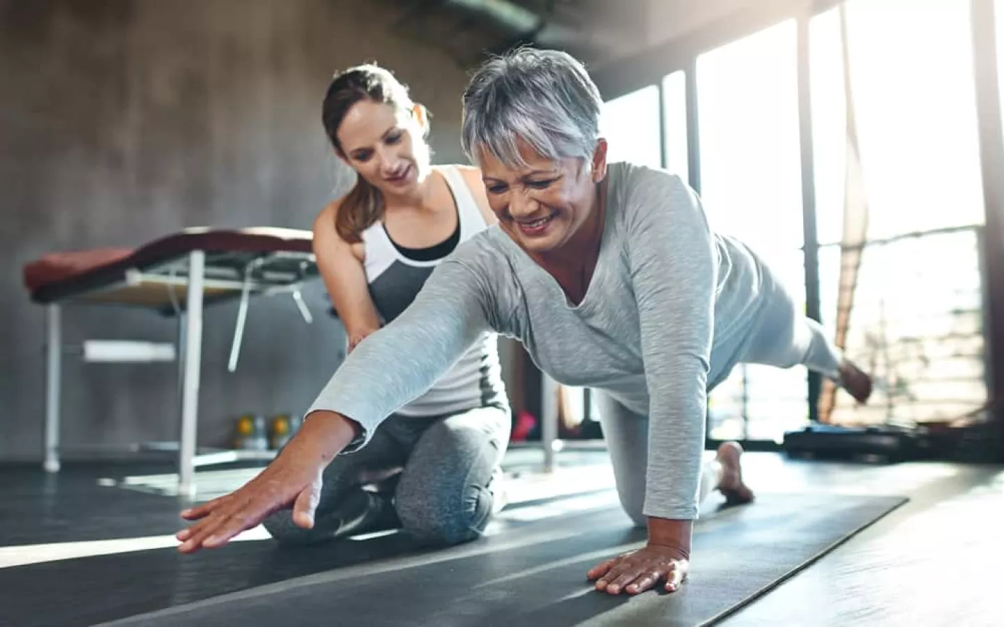 Une personne âgée fait une séance de sport avec une coach