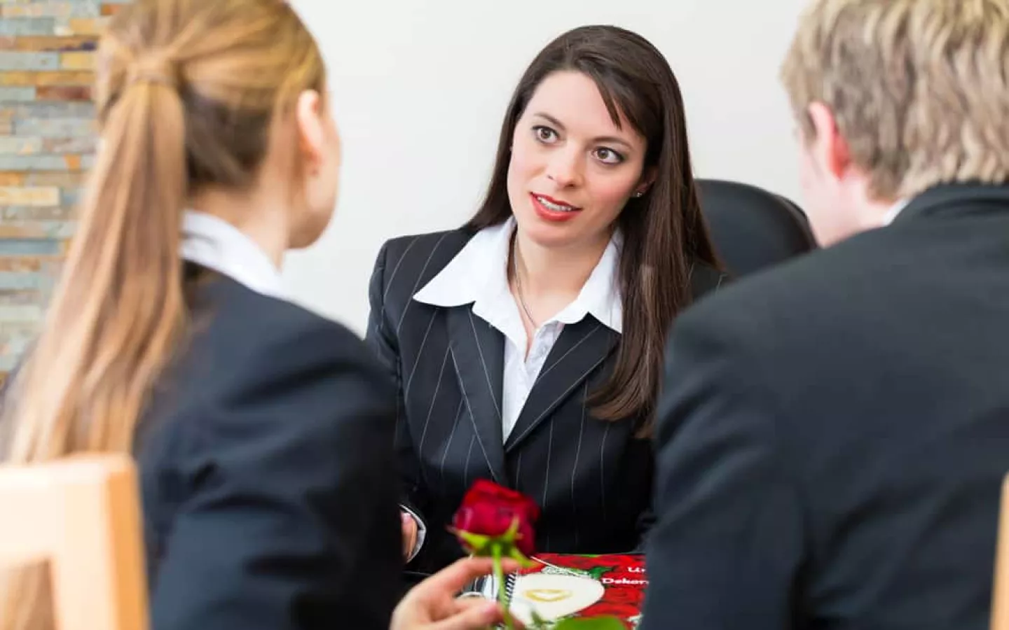 une femme explique l'assurance obsèques à un couple