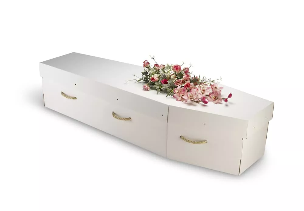 Cercueil blanc en carton orné d'une composition florale