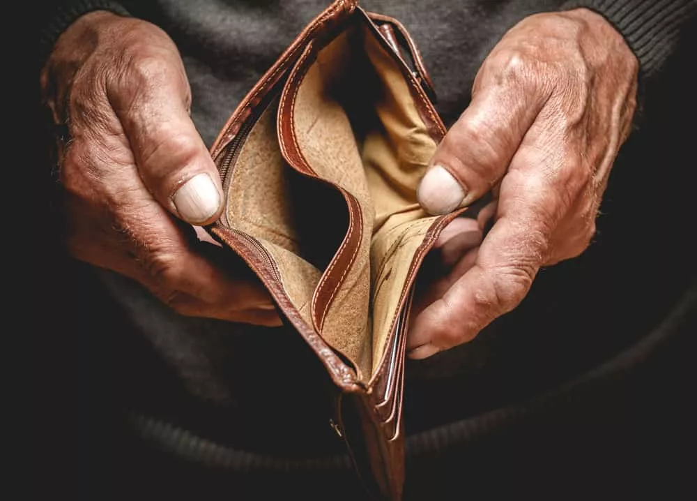Une personne âgée qui tient un portefeuille vide