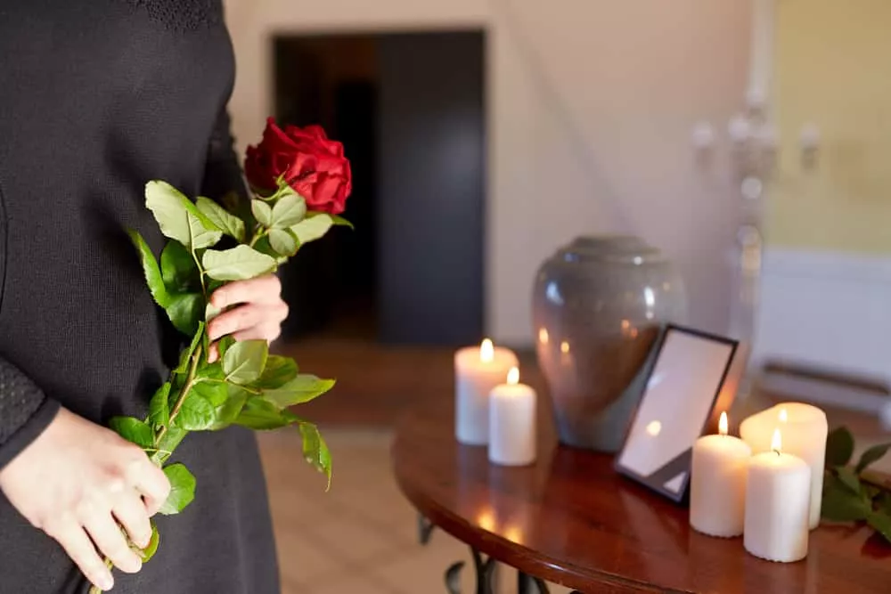 Femme qui assiste aux funérailles d'un proche après sa crémation