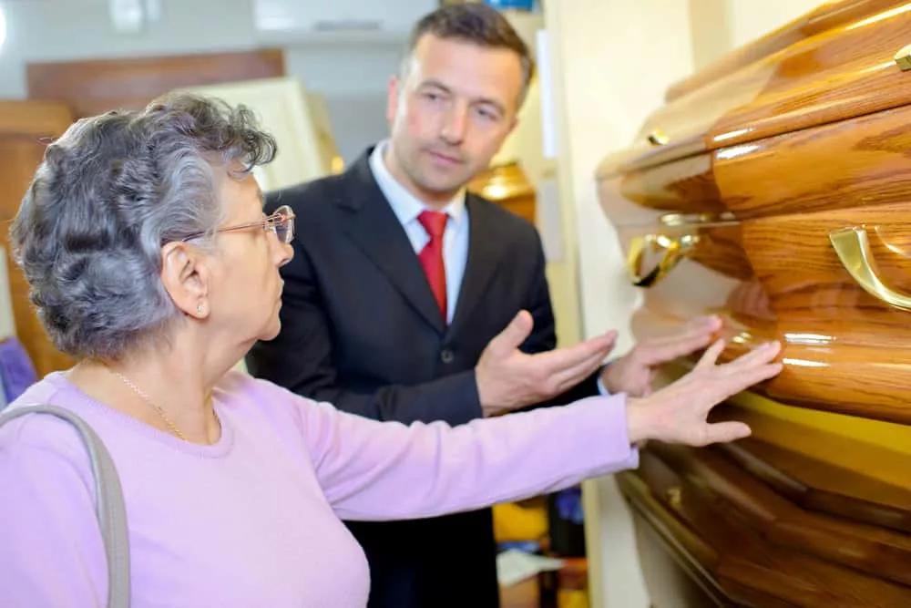 Une personne âgée qui se renseigne sur le prix d'un cercueil