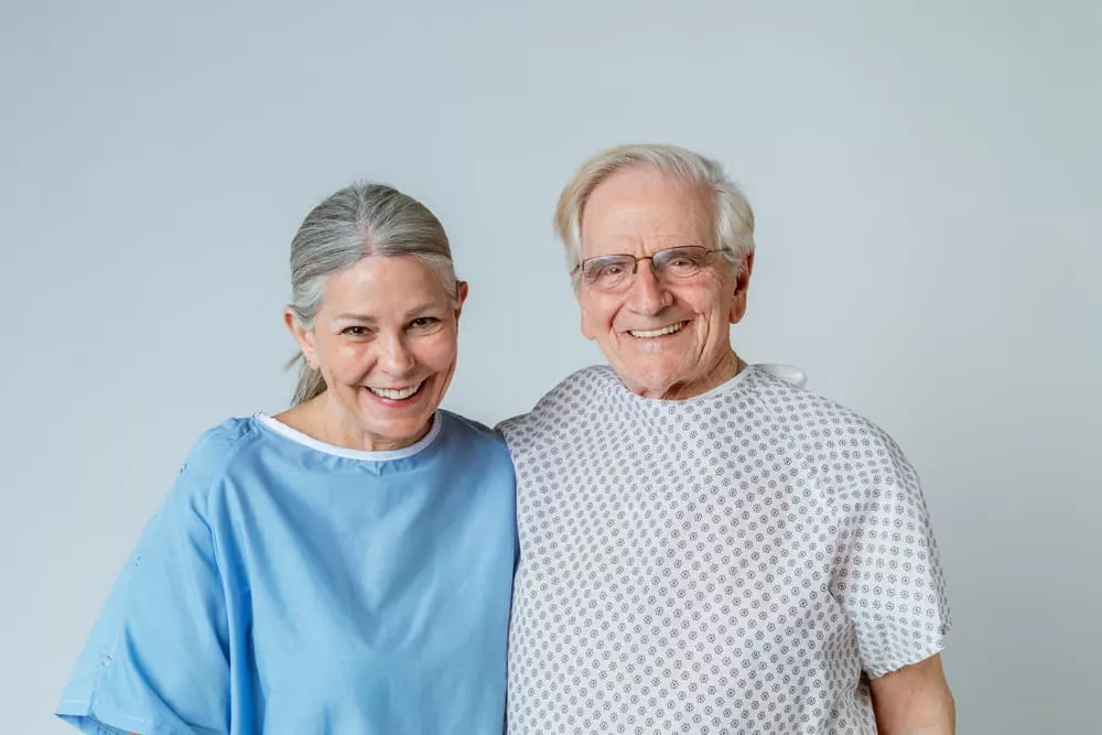 Deux personnes âgés en tenue d'hôpital