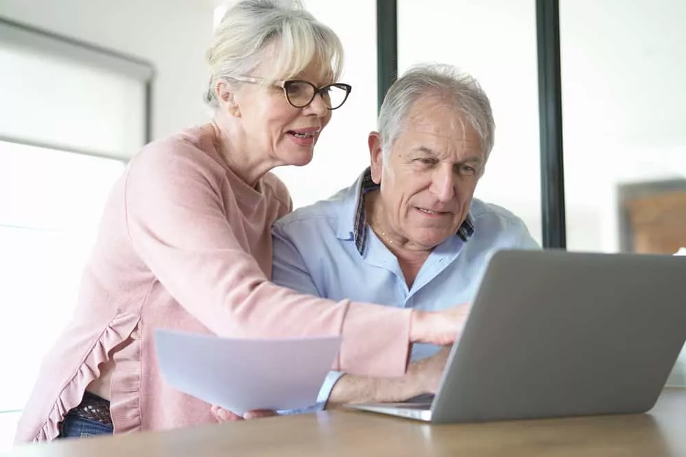 couple âgé qui regarde sur un ordinateur l'âge pour souscrire à une assurance obsèques