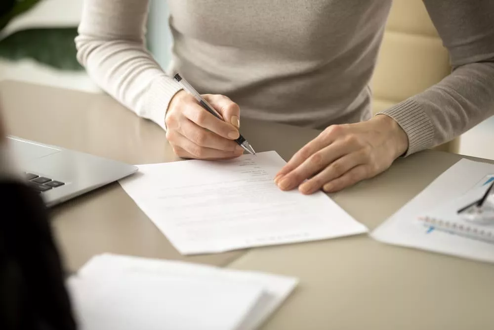 Une personne qui rédige sa lettre de remboursement d'assurance de prêt immobilier